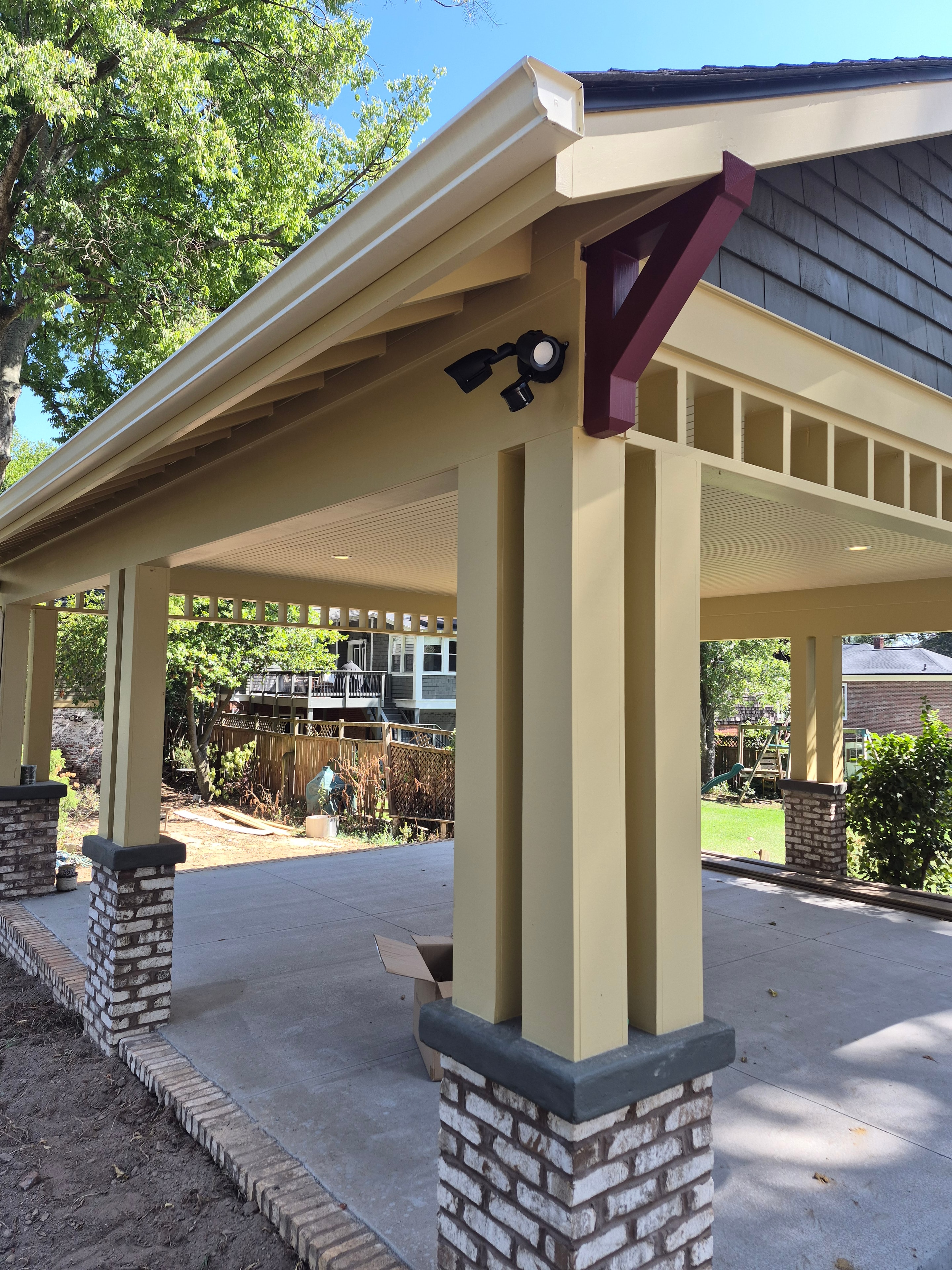 Exterior motion-sensor security light installed under porch eave