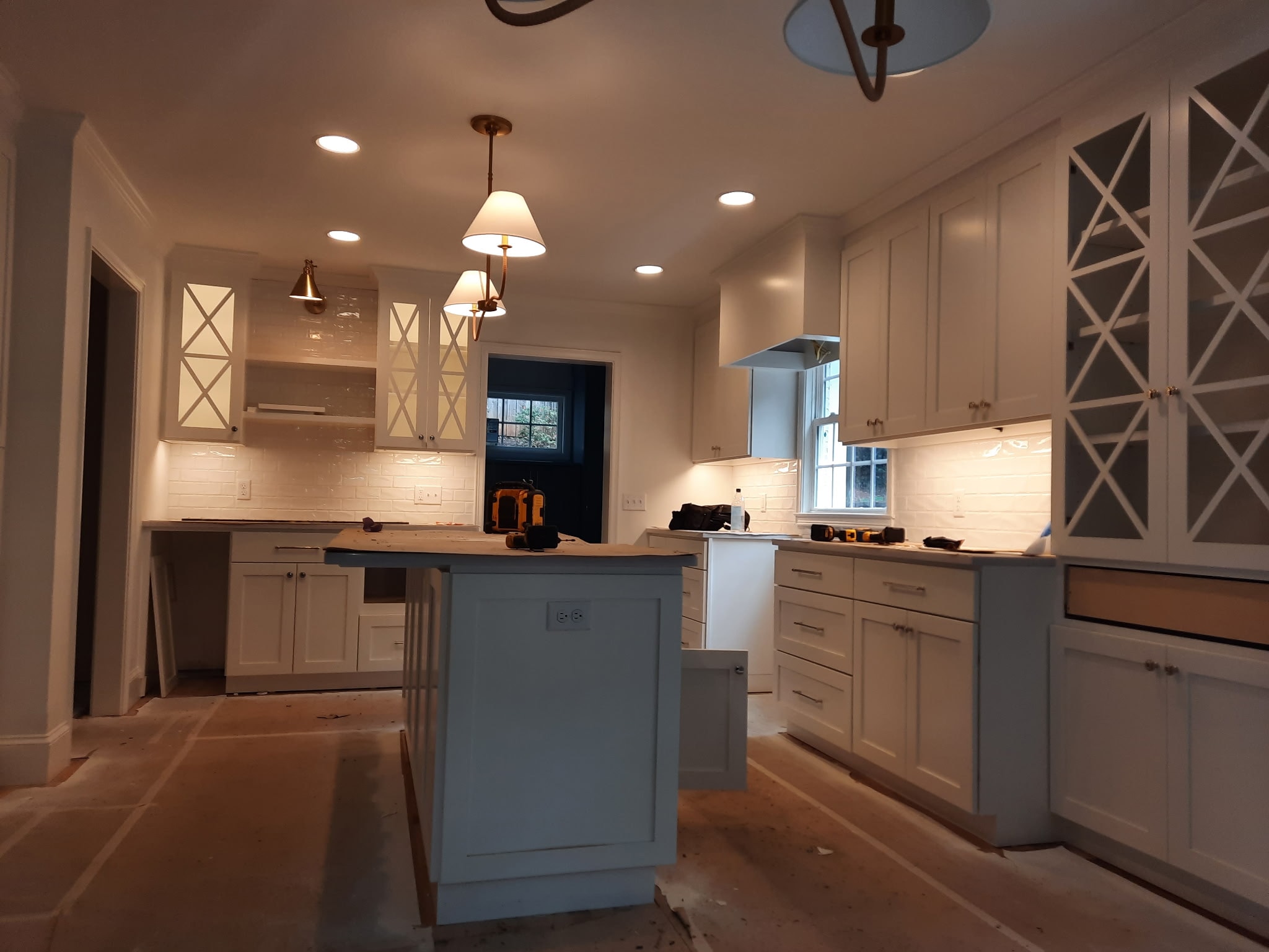White kitchen renovation with recessed and pendant lighting