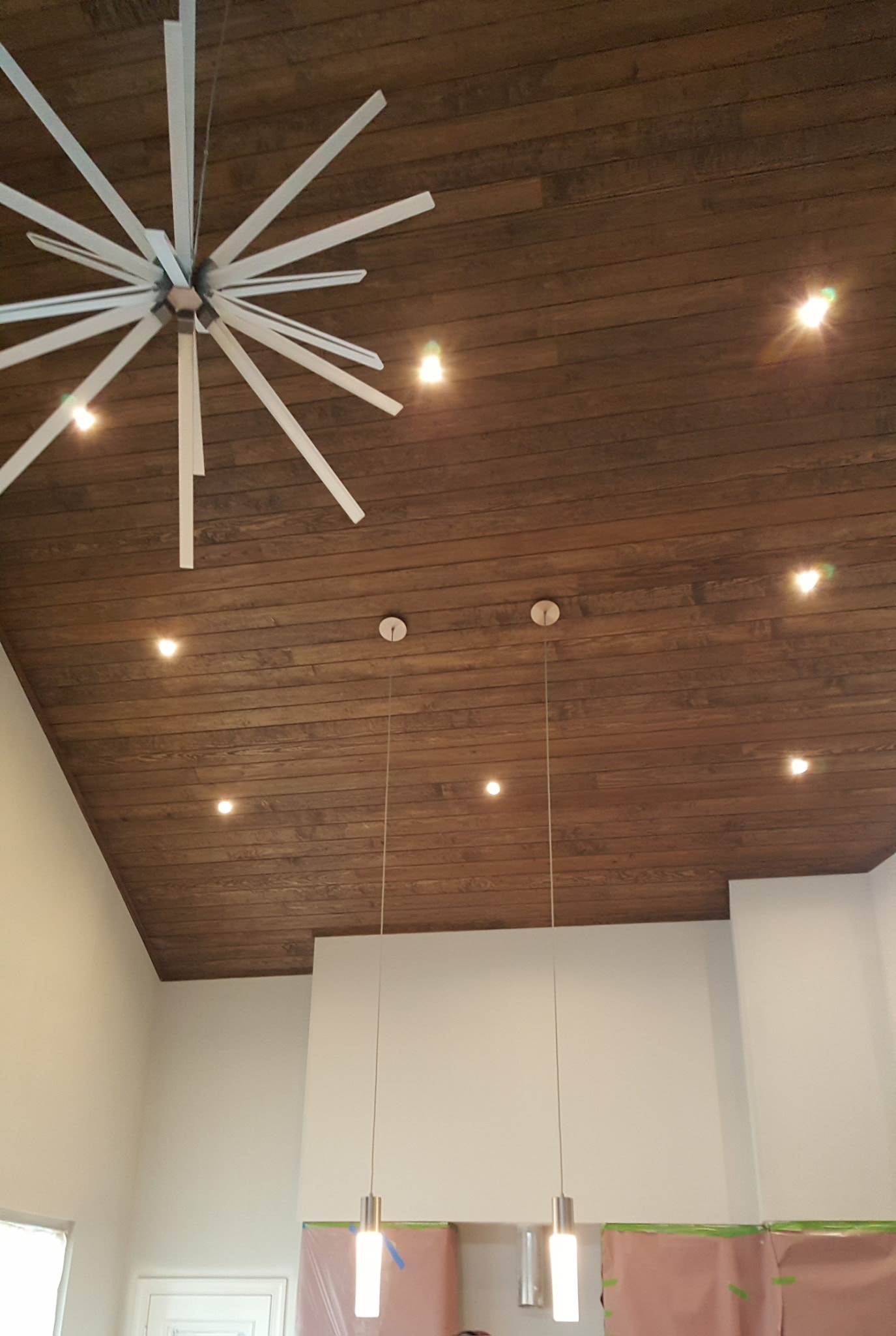 Wood ceiling with recessed and pendant lighting installation